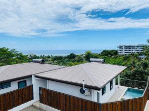 a house with a metal roof and a swimming pool at Villa Nanihivai - maison moderne avec piscine privée in Faaa