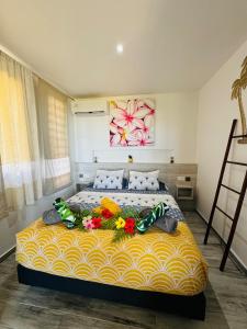 a bedroom with a bed with flowers on it at Villa Nanihivai - maison moderne avec piscine privée in Faaa +27 photos
