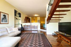 a living room with a couch and a flat screen tv at Villa Mattei in Oristano