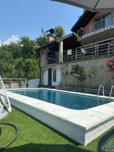 a swimming pool in front of a house at Vila sa bazenom Lily in Konjic