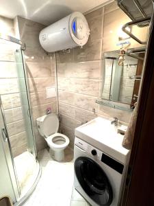 a small bathroom with a toilet and a washing machine at Cozy apartment on Sunny Beach in Sunny Beach