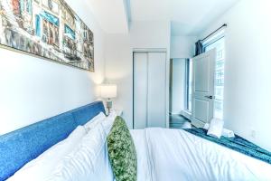 a bedroom with a bed and a window at RivetStays - The Jarvis in Toronto