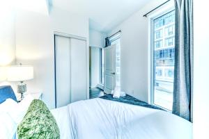 a bedroom with a bed and a large window at RivetStays - The Jarvis in Toronto