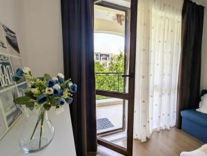 a vase of flowers sitting on a table next to a door at Cozy apartment on Sunny Beach in Sunny Beach