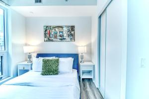 a bedroom with a bed and two night stands at RivetStays - The Jarvis in Toronto