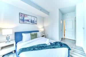 a bedroom with a large bed with a blue headboard at RivetStays - The Jarvis in Toronto