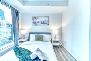 a bedroom with a bed and a large window at RivetStays - The Jarvis in Toronto