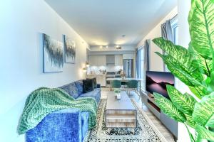 a living room with a blue couch and a table at RivetStays - The Jarvis in Toronto