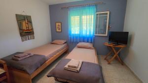 Zimmer mit 2 Betten und TV in der Unterkunft Potidaia The Garden Oasis Summer House in Nea Potidaea