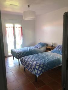 una camera da letto con due letti, un tavolo e finestre di Appartement de location meublé F3 au premier étage a Banyuls-sur-Mer