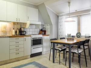 a kitchen with white cabinets and a table with chairs at 5 person holiday home in LYSEKIL in Lysekil