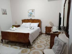 una camera da letto con un letto, una tv e un divano di Casa Monteserrato a Terrasini Altre 15 foto