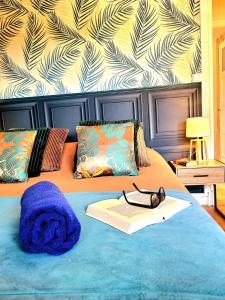 łóżko z niebieskim kocem, książką i okularami w obiekcie La Brainoise Maison familiale chaleureuse avec jardin et plage sauvage w mieście Équihen-Plage