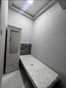 a small room with a bed and a mirror at sara apartment in Dubai