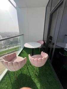 two pink chairs and a table on a glass floor at sara apartment in Dubai
