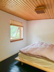 HøjbyにあるAuthentic 60'S Summer House By Ellinge Lyngのベッドと窓のある寝室
