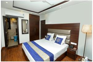 a bedroom with a large bed and a bathroom at Airport Hotel The R Blues - New Delhi in New Delhi