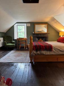 a bedroom with a bed and a chair and a table at Powis House East Cottage in Stirling