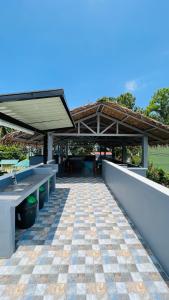 eine Außenterrasse mit einem Waschbecken und einem Tisch in der Unterkunft Sammys House Rental in Puerto Galera