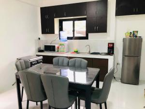 a kitchen with a table and chairs and a refrigerator at Sammys House Rental in Puerto Galera