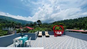 a balcony with chairs and tables and a view of mountains at Sammys House Rental in Puerto Galera +4 photos