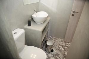 Baño blanco con lavabo y aseo en Marietta Studios, en Mérikhas