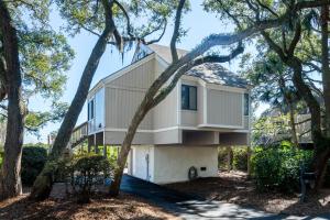 a house with a wrap around porch surrounded by trees at 815 Treeloft Cottage in Seabrook Island