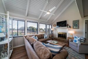 a living room with a large couch and a fireplace at 815 Treeloft Cottage in Seabrook Island
