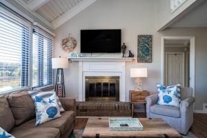 a living room with a couch and a fireplace at 815 Treeloft Cottage in Seabrook Island +20 photos