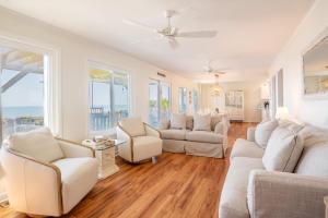 Una sala de estar con muebles blancos y grandes ventanales. en Oceanfront - Private Pool - Decks for Days, en Kure Beach 32 fotos más