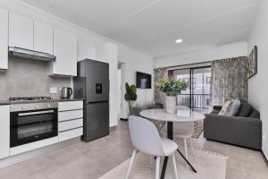 eine Küche und ein Wohnzimmer mit Tisch und Stühlen in der Unterkunft Fourways Luxe Haven, 6mins to Montecasino in Sandton