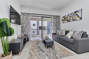 ein Wohnzimmer mit Sofa und Tisch in der Unterkunft Fourways Luxe Haven, 6mins to Montecasino in Sandton