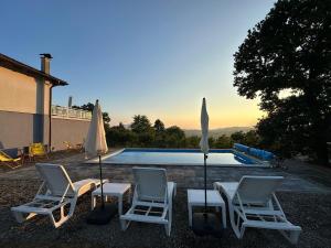 a group of chairs and umbrellas next to a swimming pool at Villa Dalia in Gračanica