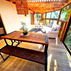 a living room with a wooden table and a couch at CASA CON TINAJA, PISCINA Y QUINCHO - Pucón in Pucón