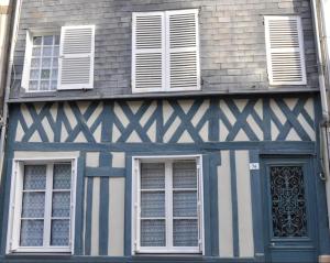 een blauw-wit gebouw met ramen en een deur bij Appartement rénové 250m du port - classé 3 étoiles in Honfleur