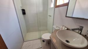 a bathroom with a sink and a shower and a toilet at Chalé Coração de Monte Verde in Monte Verde +21 photos