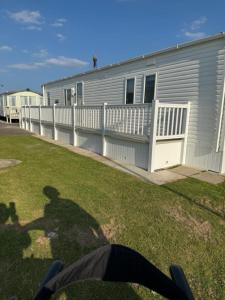 a shadow of a person in front of a mobile home at PALM GROVE THE NeW PG68 3 BEDROOM CARAVAN CHAPEL ST LEONARDS in Chapel Saint Leonards