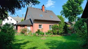 a red house with a gray roof at Symbiola Holiday House in Arnoltice u Decina