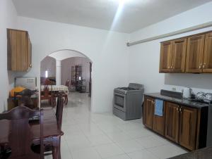 a kitchen with wooden cabinets and a table and a stove at TwentyFive at Tower Isle in Tower Isle