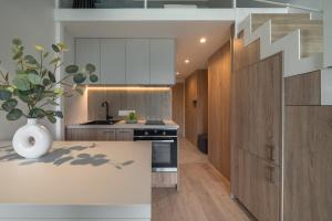 a kitchen with wooden cabinets and a staircase in a house at Loft 12 in Vilnius