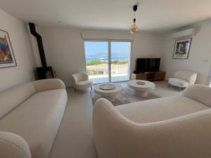 a living room with a couch and chairs and a television at Calvi - A Casa di u Mare in Calvi