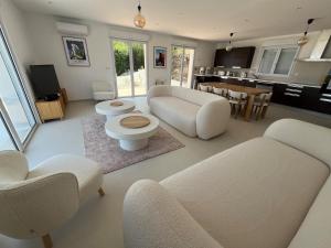 a living room with white furniture and a kitchen at Calvi - A Casa di u Mare in Calvi