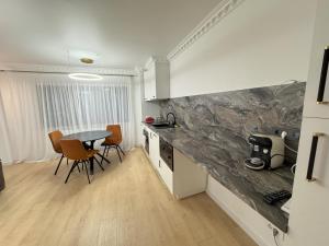 a kitchen and dining room with a table and chairs at Imedio Coral Apartment Aviatiei in Bucharest