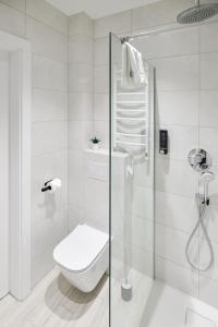 a white bathroom with a toilet and a shower at Horyzont Apartamenty Zator in Gierałtowiczki +130 photos