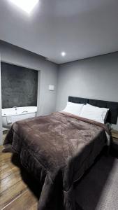 a bedroom with a large bed in a room at Chalé Jaguary com hidro,Monte Verde MG in Companhia