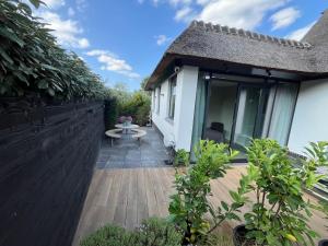 a patio with a table and a fence at Duinpoort Appartement in Castricum