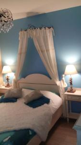 a bedroom with a bed with a curtain and two lamps at Villa Lescala in Blaye