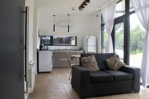 a living room with a couch and a kitchen at Complejo Duendes del Maiten in San Carlos de Bariloche