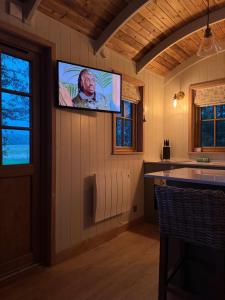 a tv hanging on a wall in a kitchen with at Dreamers Hut in Dipton +2 photos
