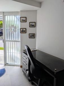 an office with a black desk and a chair at Alojamiento privado ubicado en la mejor zona de Manizales in Manizales